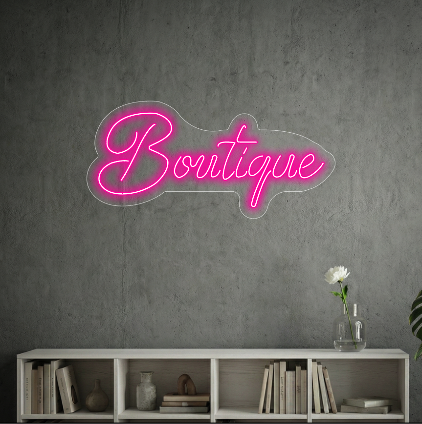 Neon z napisem "Boutique" na tle szarej ściany