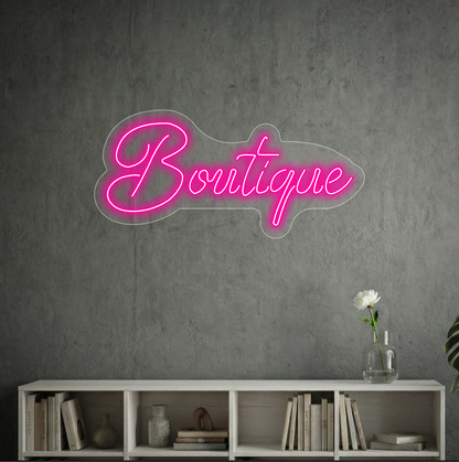 Neon z napisem "Boutique" na tle szarej ściany