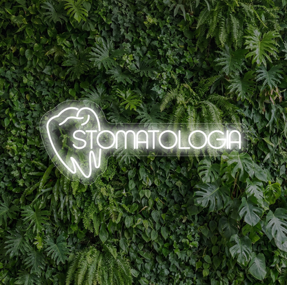 Neon z wizuerunkiem zęba i napisem "stomatologia" na tle ścianki z iści