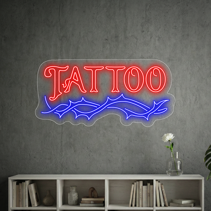 neon z napisem "tattoo" na tle szarej ściany w poczekalni lokalu